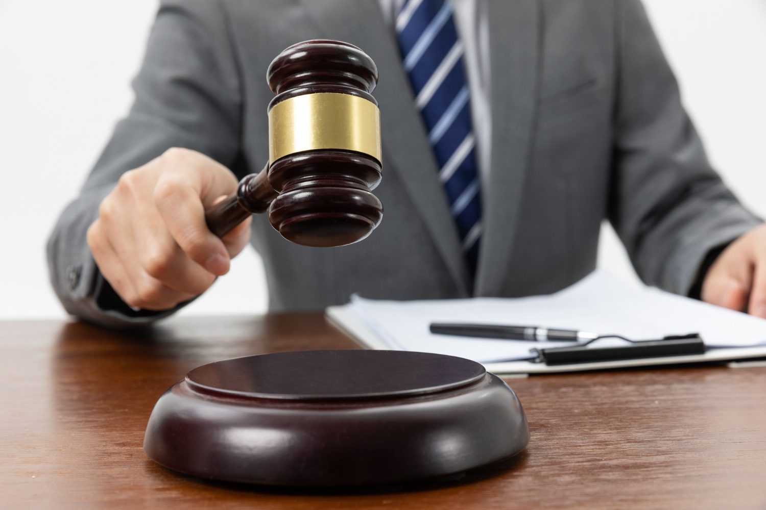 closeup shot of a person holding a gavel on the table closeup shot of a person holding a gavel on the table